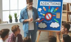 Imagen de un profesor dando una charla sobre adicciones a jóvenes
